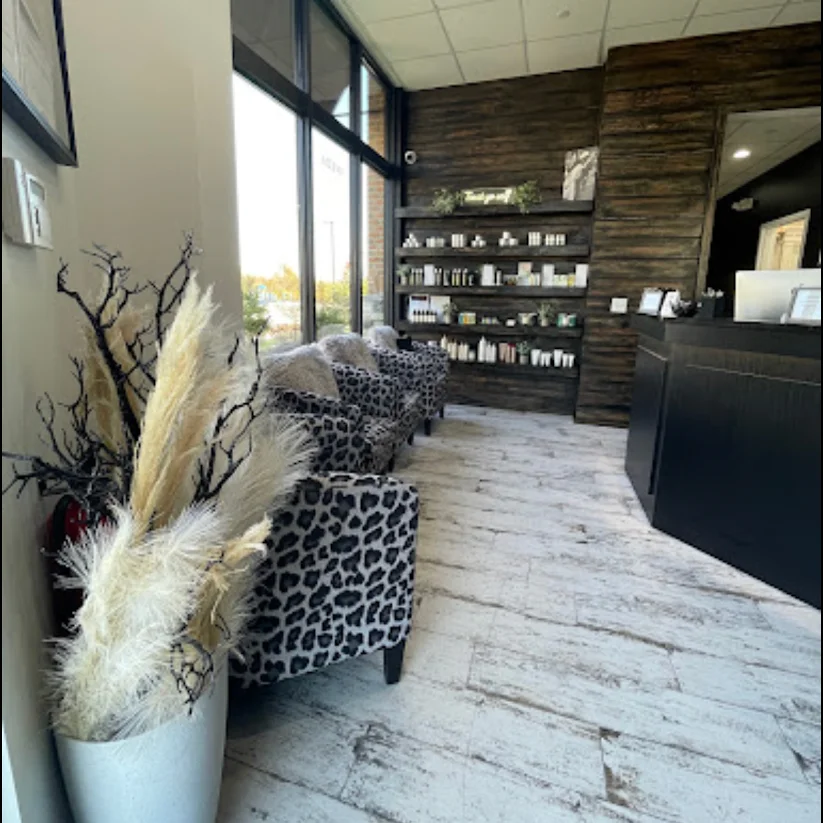 Interior view of a salon reception and styling area with chairs, mirrors, and modern furnishings